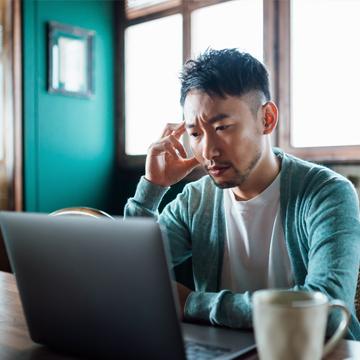 一名忧心忡忡的男子正在阅读有关欺骗企图的最新消息